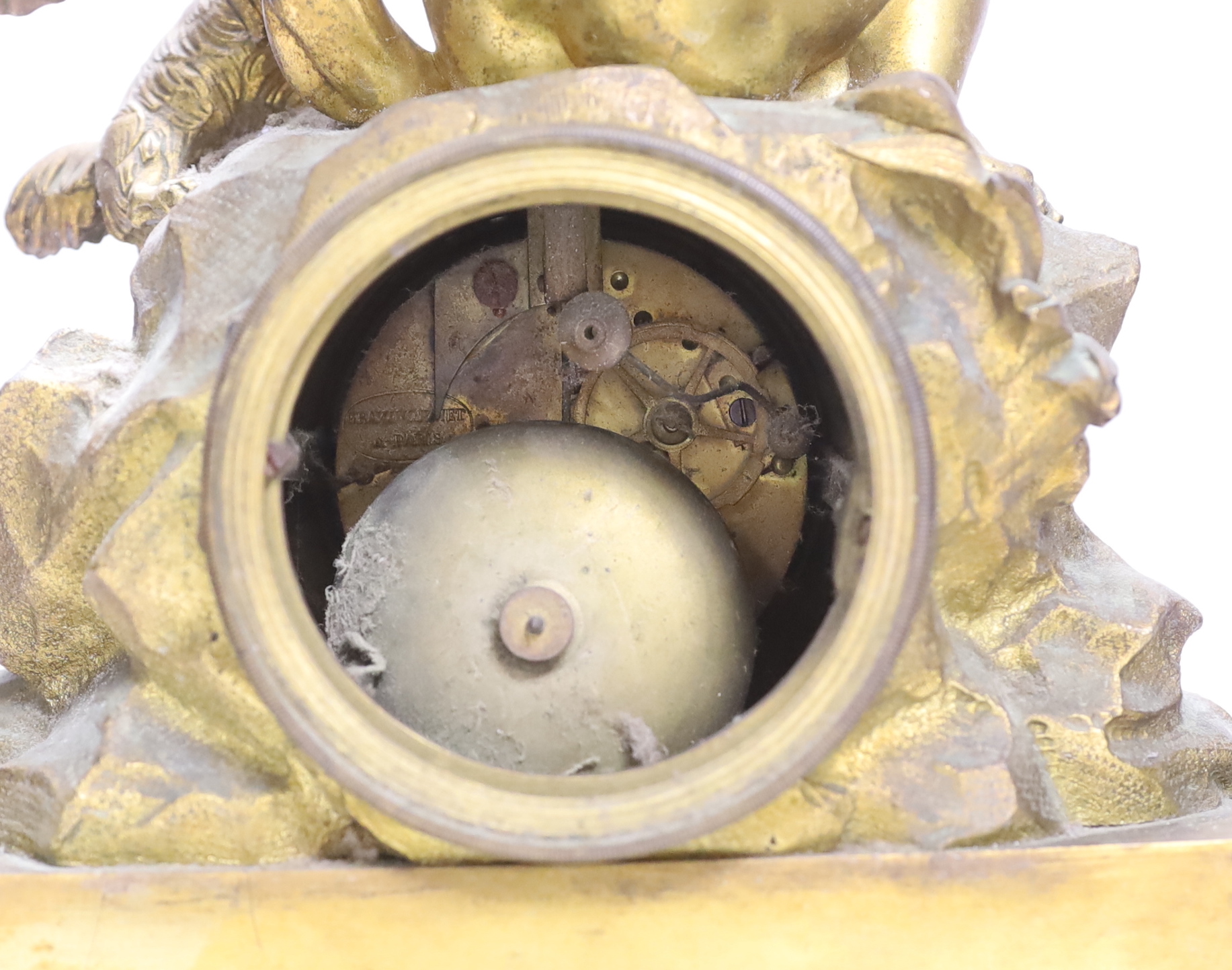 A decorative French ormolu mantel clock, the top a child playing with a kitten and the base with scrolled feet below a swag of flowers, 42cm high